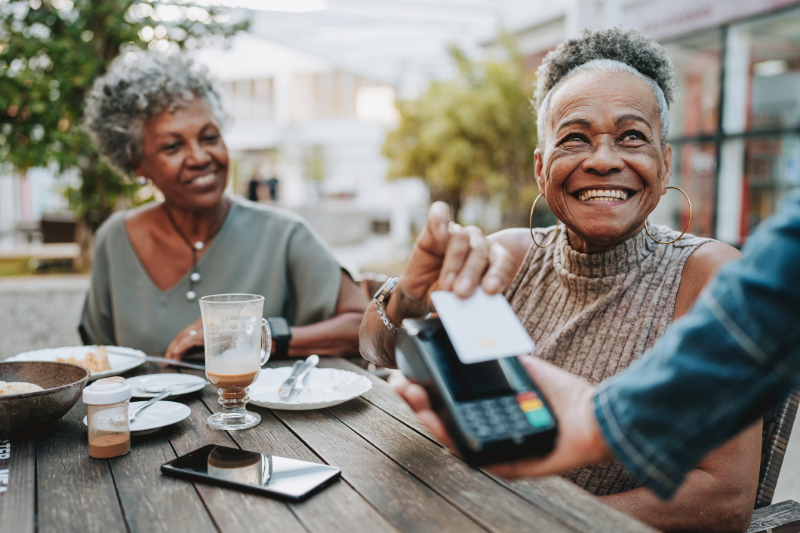 Woman paying for lunch with a friend.