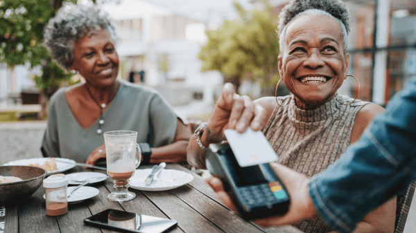 Woman paying for lunch with a friend.