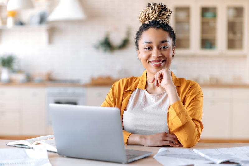 African American woman sitting at a table in front of a laptop