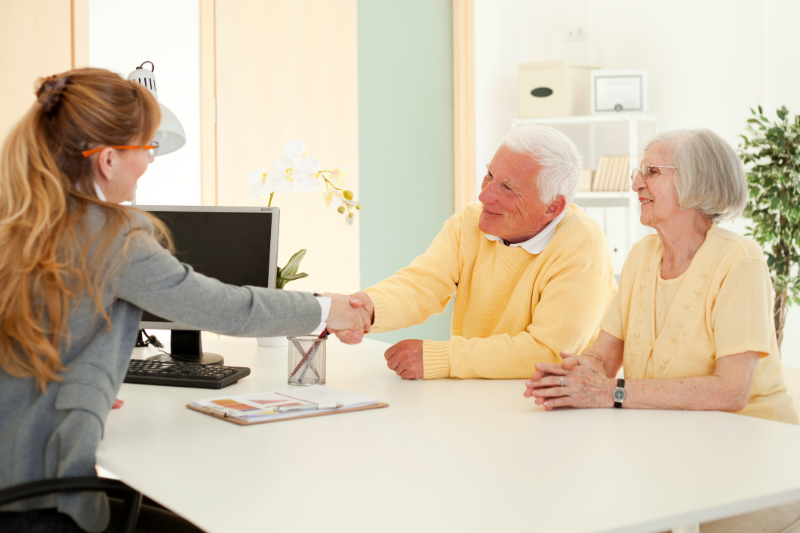 An older couple sitting across from a business woman at a desk