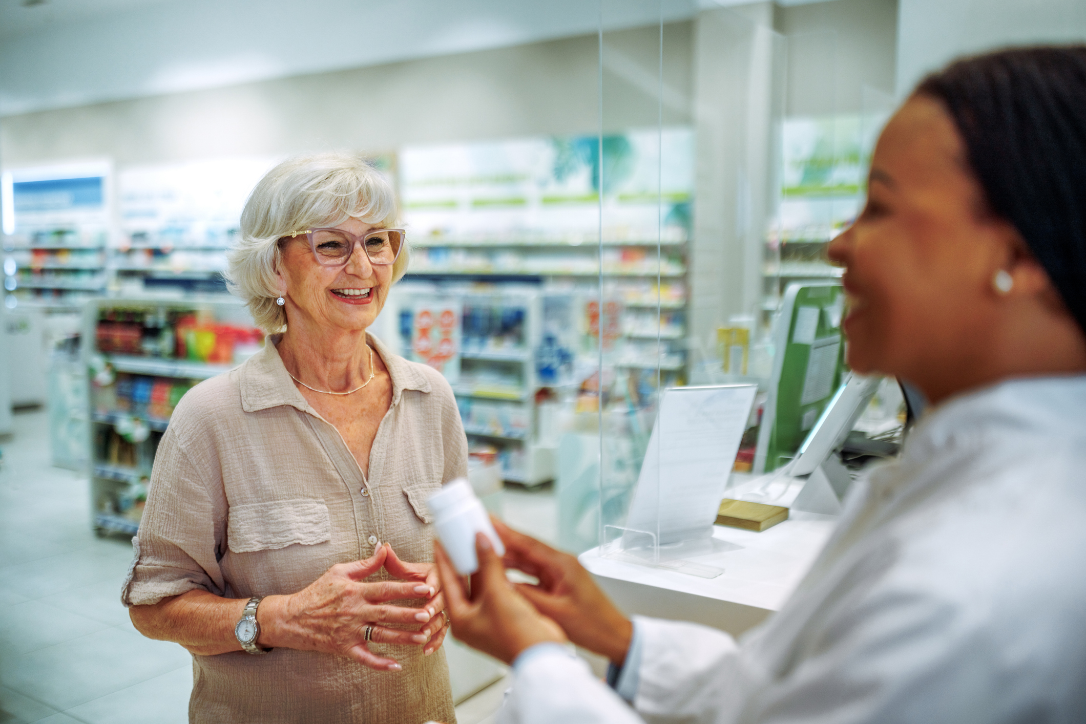 Pharmacist speaking with a senior at the pharmacy