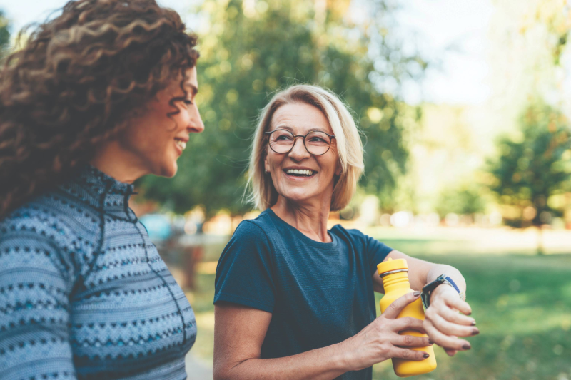 Two senior women walking in the park