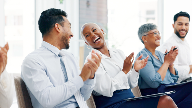 Business people clapping and laughing together in an office